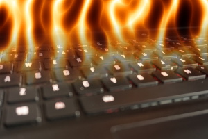 Photograph of laptop keyboard with overlaid image of fire.